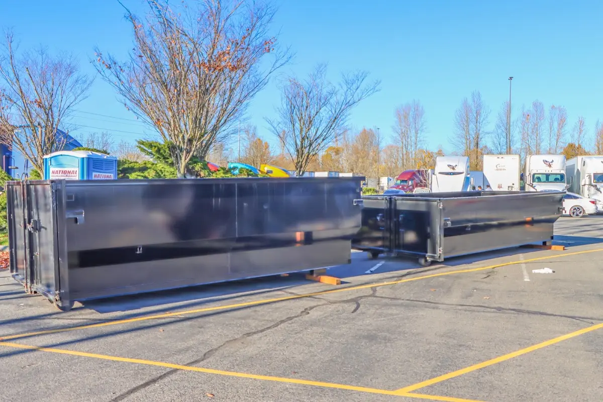 Professional dumpster rental service with roll-off container on residential driveway in Bozeman